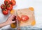 Hand slicing fresh garden tomato on natural bamboo cutting board