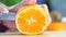 Hand slicing a orange with a knife