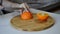 Hand slicing orange on wooden board. Housewife woman slicing fresh orange fruits on cutting board for salad or juicing in kitchen