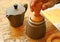 Hand Slightly Tapping Ground Coffee with Wooden Tamper for a Flat Surface before Brewing Aromatic Coffee