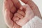 The hand of a small child on the palm of the mother. A close-up of a child\'s hand in a mother\'s. Family scene
