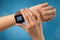 Hand with smartwatch and blue background