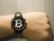 Hand with a smartwatch, that has a bitcoin symbol