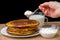 Hand with a spoon of sour cream and pancakes