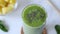 Hand sprinkling chia seeds on top of green detox smoothie