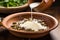 hand sprinkling feta cheese on a quinoa and olive bowl