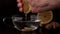 Hand squeezing lemon into cup of hot water and ginger