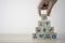 Hand stacking healthcare medicine and hospital icon which printed screen on wooden cubes on table. Health care insurance business