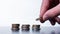 Hand stacking small coins on  a table