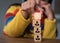 Hand stacking wood blocks on a table with the symbols Action plan, Goal and target, success and business target concept,