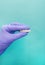 Hand of stomatologist holding plastic denture teeth over isolated blue background