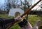 Hand stretches bowstring in archery gloves near wooden tissue bow arrow with feather wings wood target straw target aim shoot