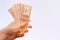 Hand stretches US hundred-dollar bills  on white background. Payment, fee, credit