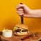 Hand stubbing burger with knife