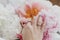 Hand with stylish rings on beautiful peonies bouquet. Tender image. Feminine essentials