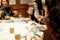 Hand of stylish woman holding glass of champagne and toasting at luxury restaurant, space for text