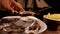 Hand takes fresh oysters from a white plate on the background of the model ship