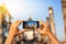 A hand taking photo of Buddha statue with smartphone, Sukhothai, Thailand