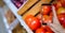 Hand taking picture of tomatoes through smart phone at grocery shop