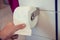 Hand taking white toilet pape