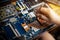 Hand technician repairing broken laptop notebook computer with a screwdriver