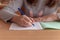 hand of a teenage girl writes with ballpoint pen in a terad during a lesson at school