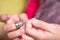 A hand with thimble knotting and cutting a thread on a needle in a sewing session