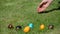 Hand throw colorful eggs on grass. Traditional Easter games