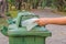 Hand throwing bottle in trash cans