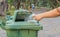 Hand throwing bottle in trash cans