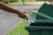 Hand throwing bottle in trash cans