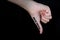 Hand in thumbs down gesture with words social media written on thumb against black background