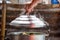 Hand to holding Lid of steaming container, The smoke floated up from the steaming container, .Thai desserts in a steamed container