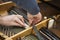 Hand and tools of tuner working on grand piano