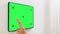 Hand touching tablet pc green screen at smart home
