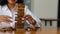 Hand tower of Asian businesswoman building a tower with wooden blocks in the office, playing games, sitting at her desk. plan futu