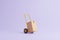 Hand truck with brown cardboard box on a pastel lilac background