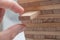 Hand try to take off piece of wooden brick of construction game