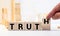 Hand turned wood cube and changes the word Trust to Truth