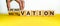 Hand turns cubes and changes the word `innovation` to `motivation` or vice versa. Beautiful yellow table, white background.