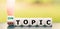 Hand turns a dice and changes the expression `off topic` to `on topic`.