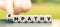 Hand turns dice and changes the word `sympathy` to `empathy`.