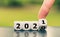 Hand turns a dice and changes the year `2020` to `2021`.