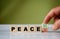 hand turns the wooden cube and changes the word PEACE with green positive tick check box and red reject X check box
