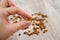 A hand  two fingers holds raisins against a background of raisins. Close-up.