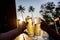 The hand of two people holding a glass of beverage and cheer each other to celebrate in the pool In the tropical garden