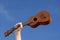 Hand and ukulele against blue sky
