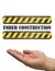 Hand under construction sign white