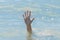 A hand from under the water of a drowning girl, help and urgent rescue of a person during a dangerous swimming, sos