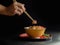 Hand use bamboo stick for Rice topped with pork  on black background, raw food Japanese food court concept